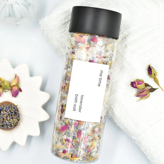 Bottle of lavender bath salts with a black lid on a light background
