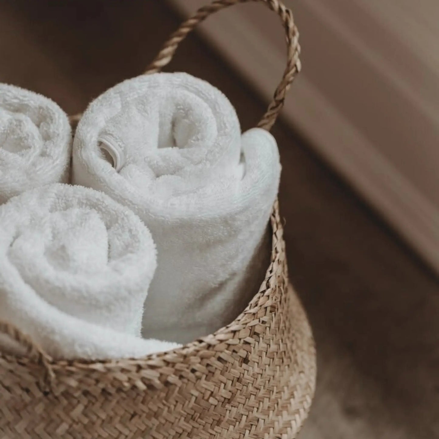 Set of three soft cotton face towels styled in a calm, minimal bathroom setting