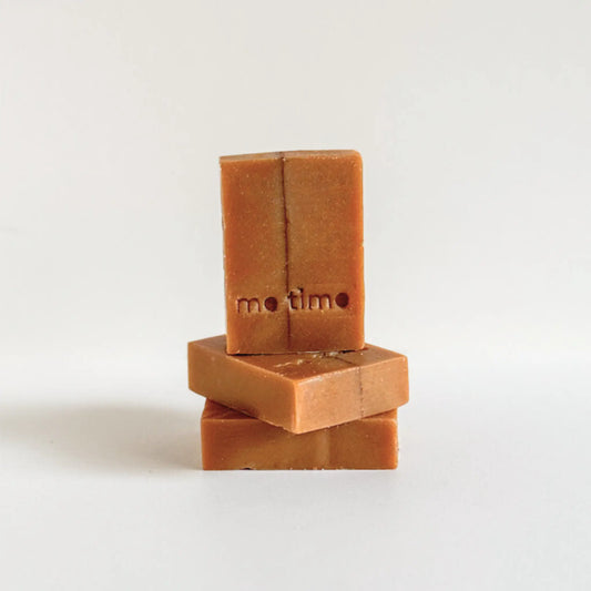 Handmade pumpkin soap bar with warm orange tones and subtle clay texture, enriched with turmeric and coconut milk, on a neutral background. me time soaps, UAE