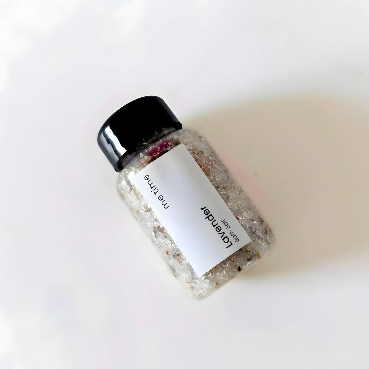 Bottle of bath salts with a label on a white background