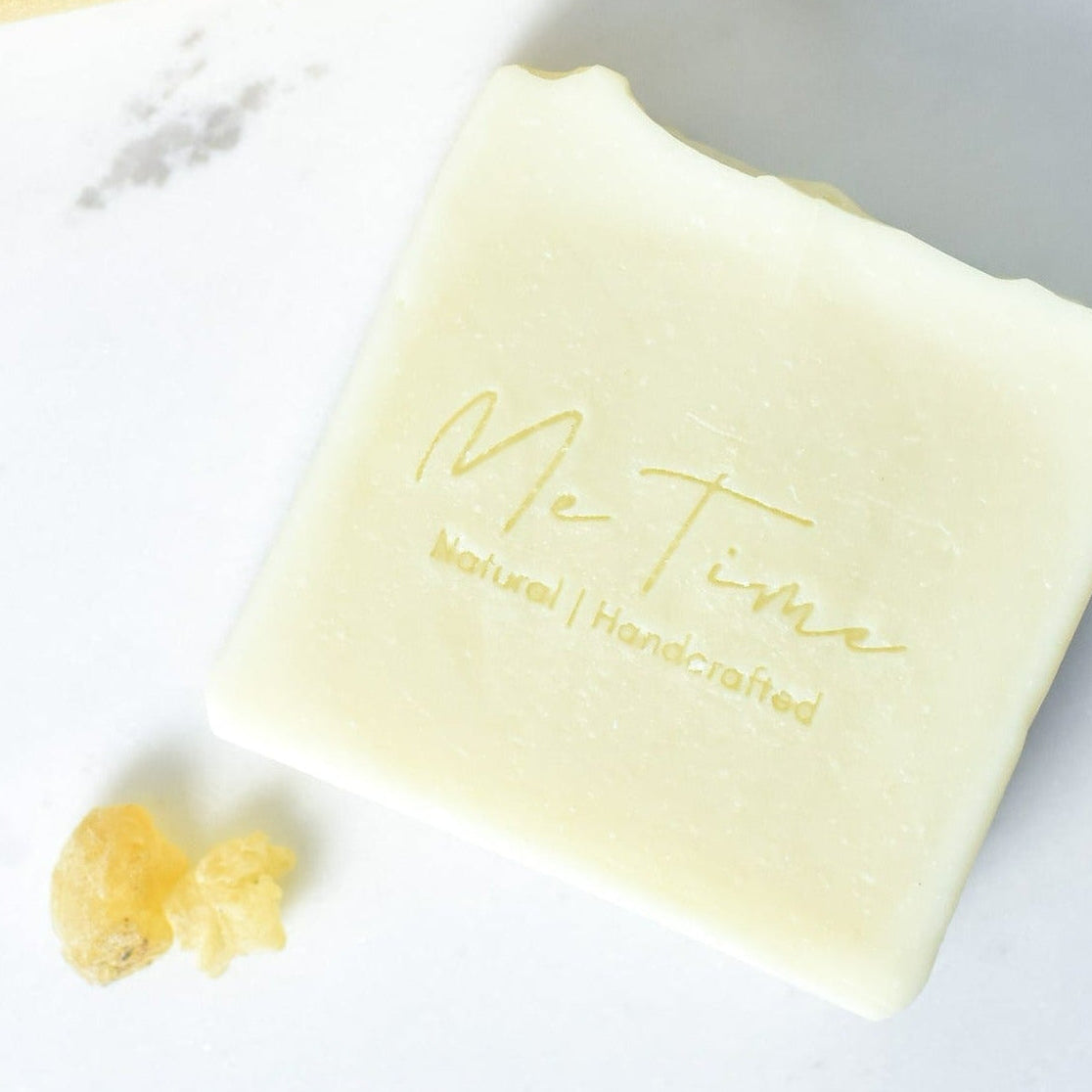 Handmade frankincense soap bar with subtle white clay tones and natural oils, photographed on a neutral background.