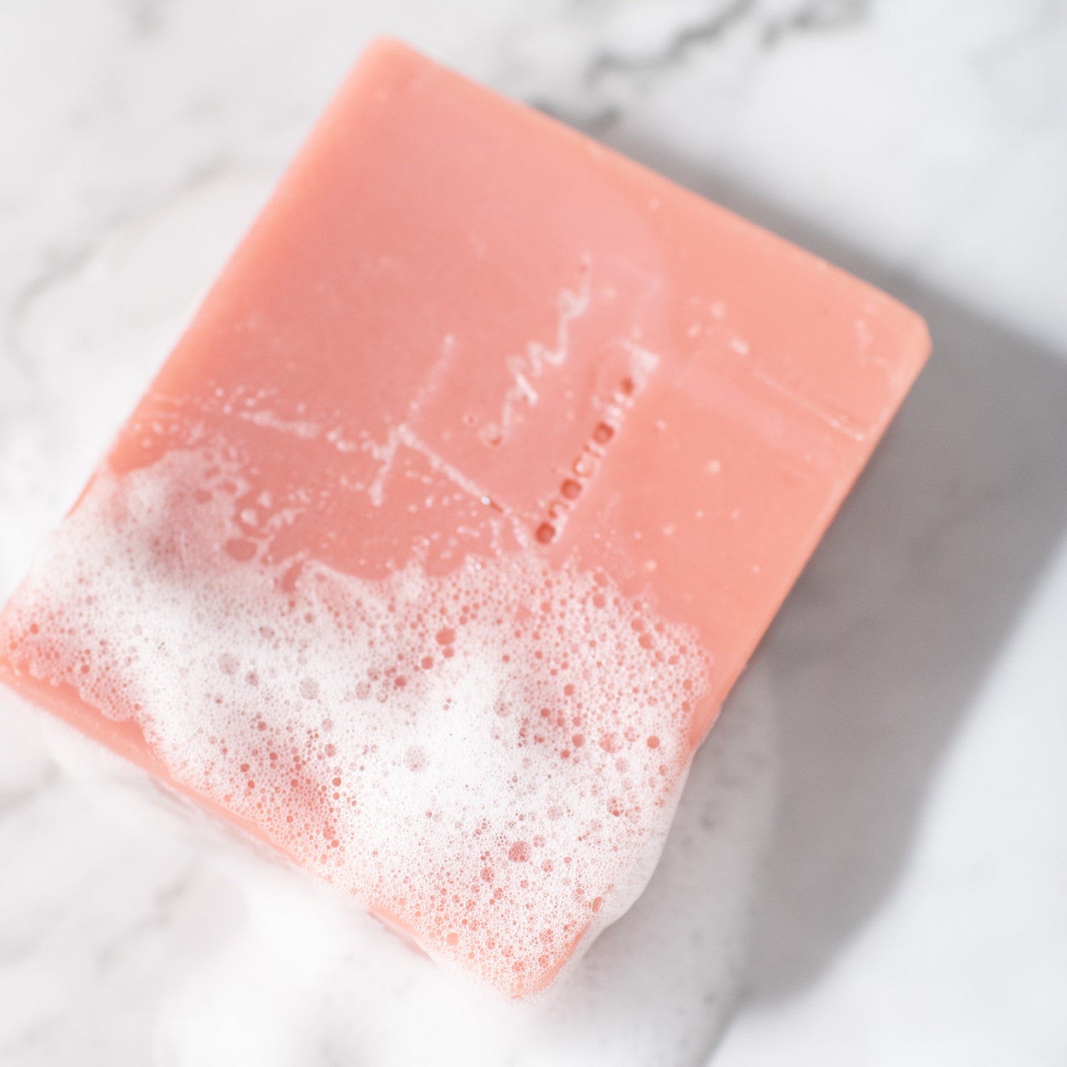 Luxurious pink clay soap bar with a hint of rose on a natural background.