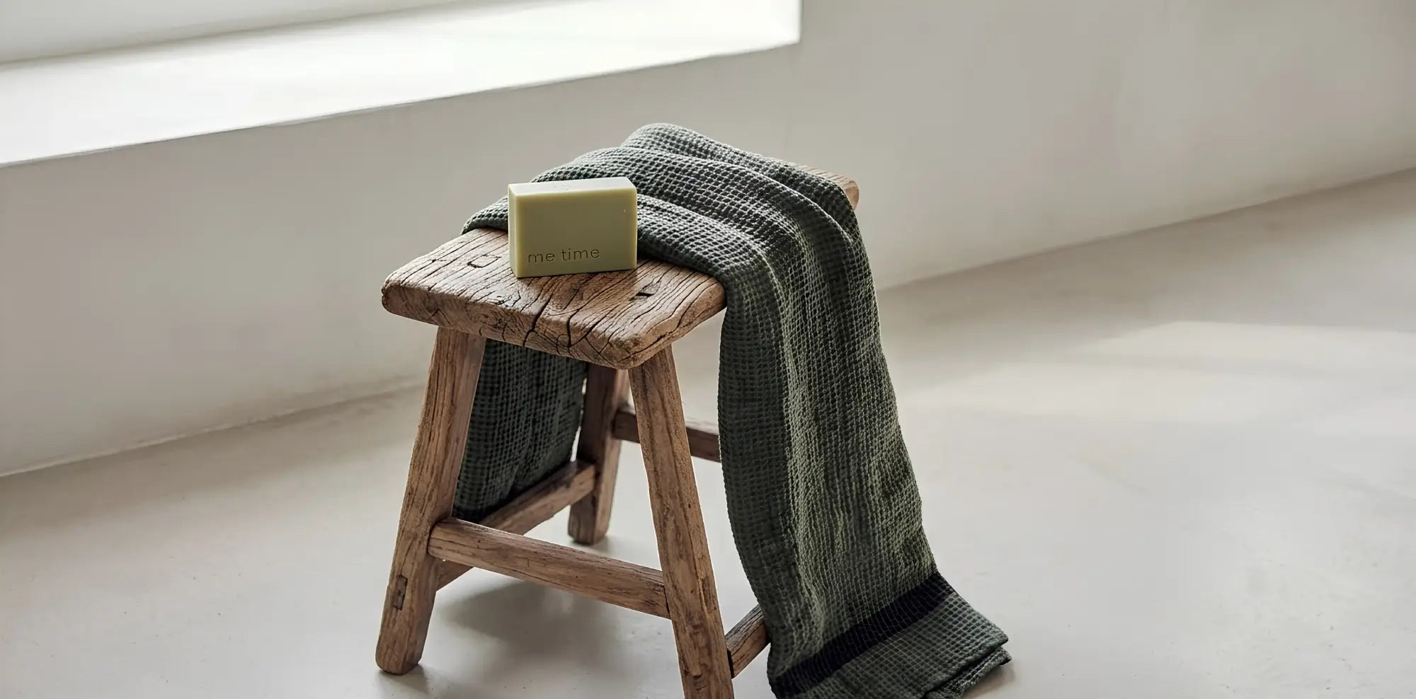 Natural handmade soap from me time soaps on a wooden stool in a minimalistic room.