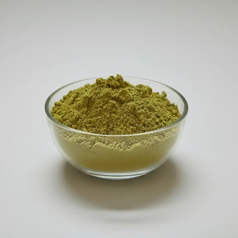 Glass bowl filled with green powder on a white background