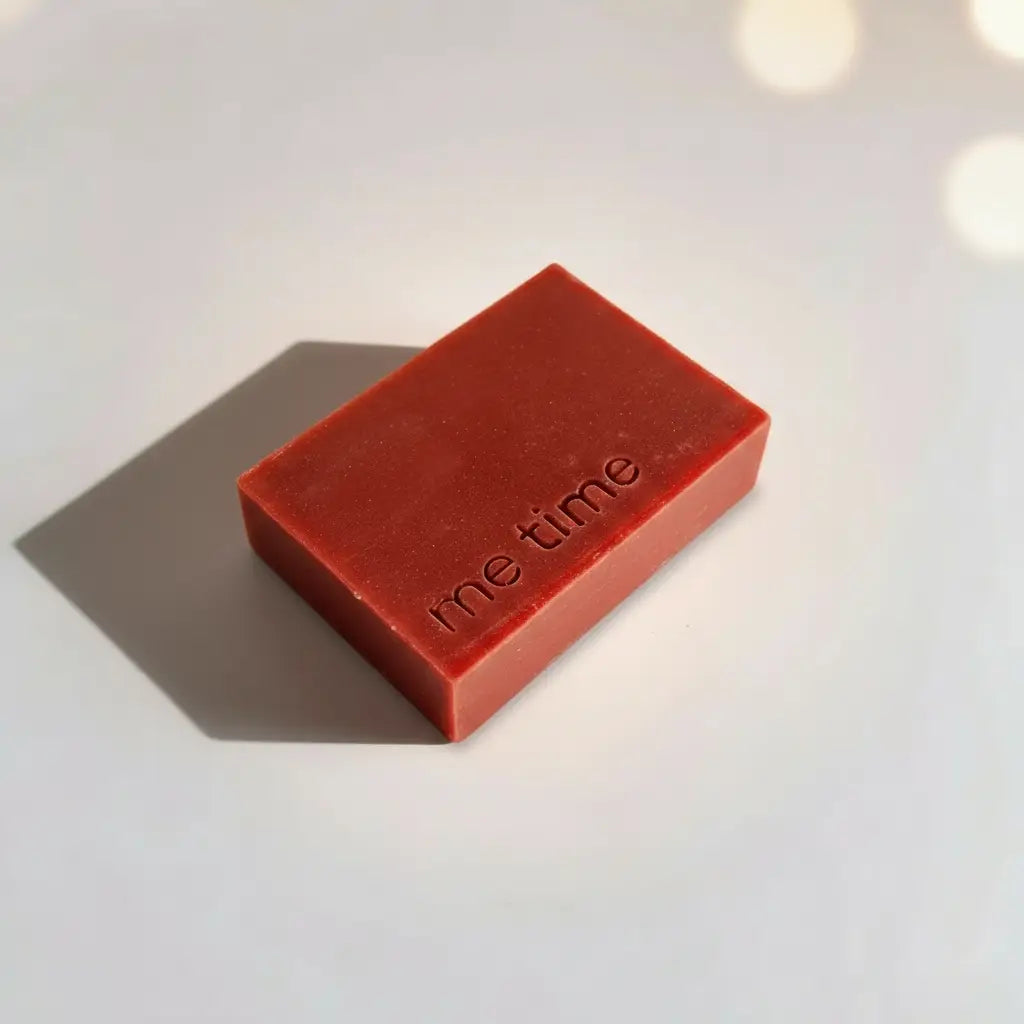 A natural handmade soap bar in warm earthy tones, softly lit on a clean neutral background. Visible cold‑process texture, minimal shadows, quietly premium feel.