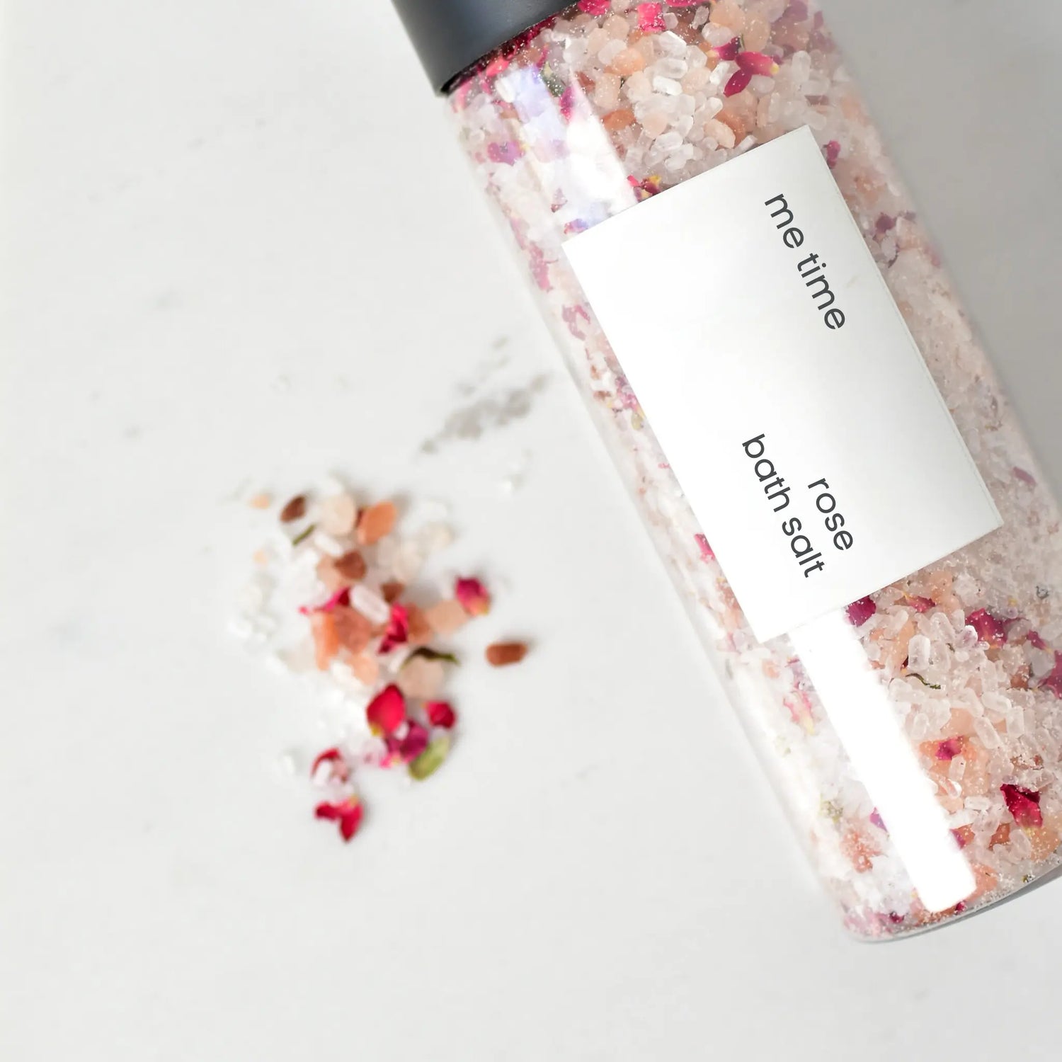 Handcrafted rose bath salt in a jar with visible rose petals, soft neutral background, spa-like aesthetic.