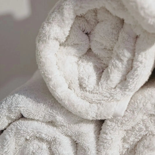 Set of three soft cotton face towels styled in a calm, minimal bathroom setting