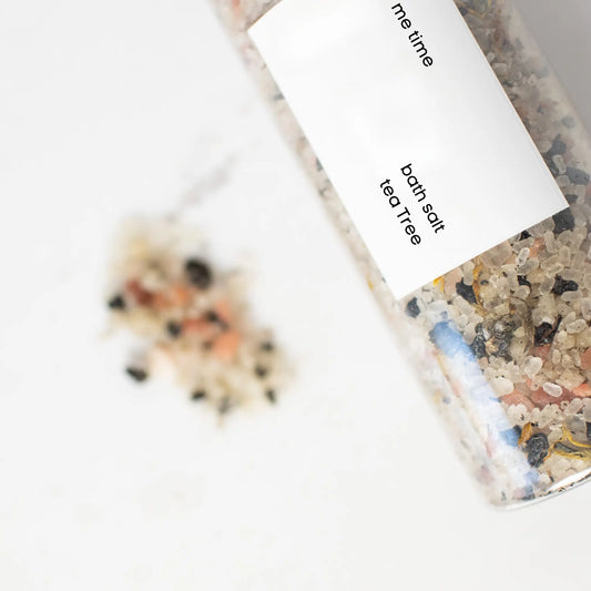 Bath salt packaging with visible ingredients on a white background