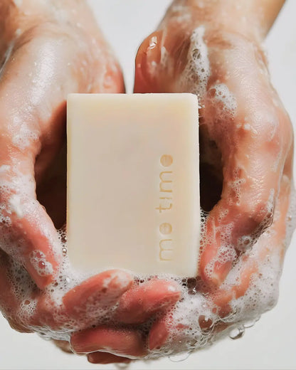 Hands holding me time soap bar with on a white background