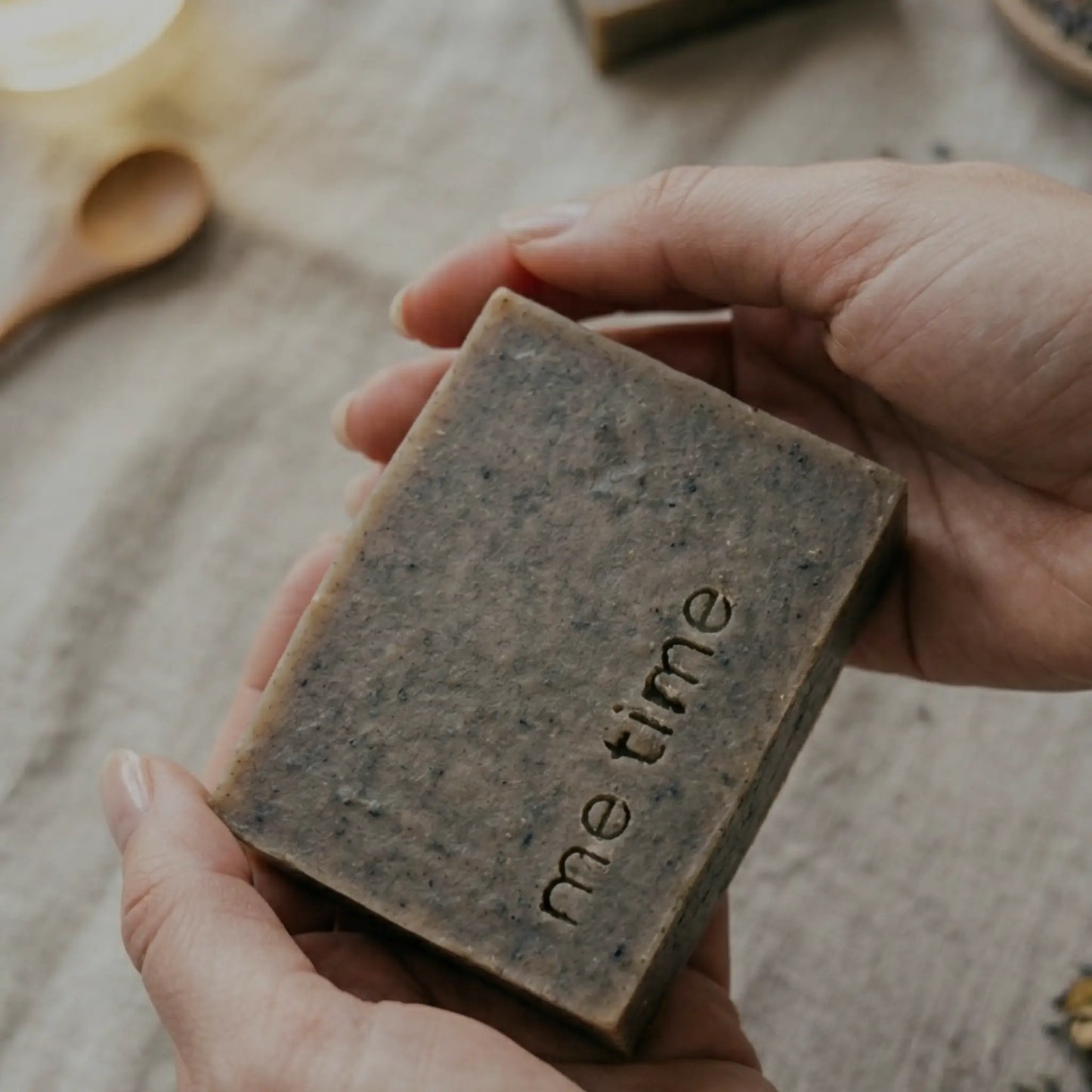 Hand holding a me time black seed soap.