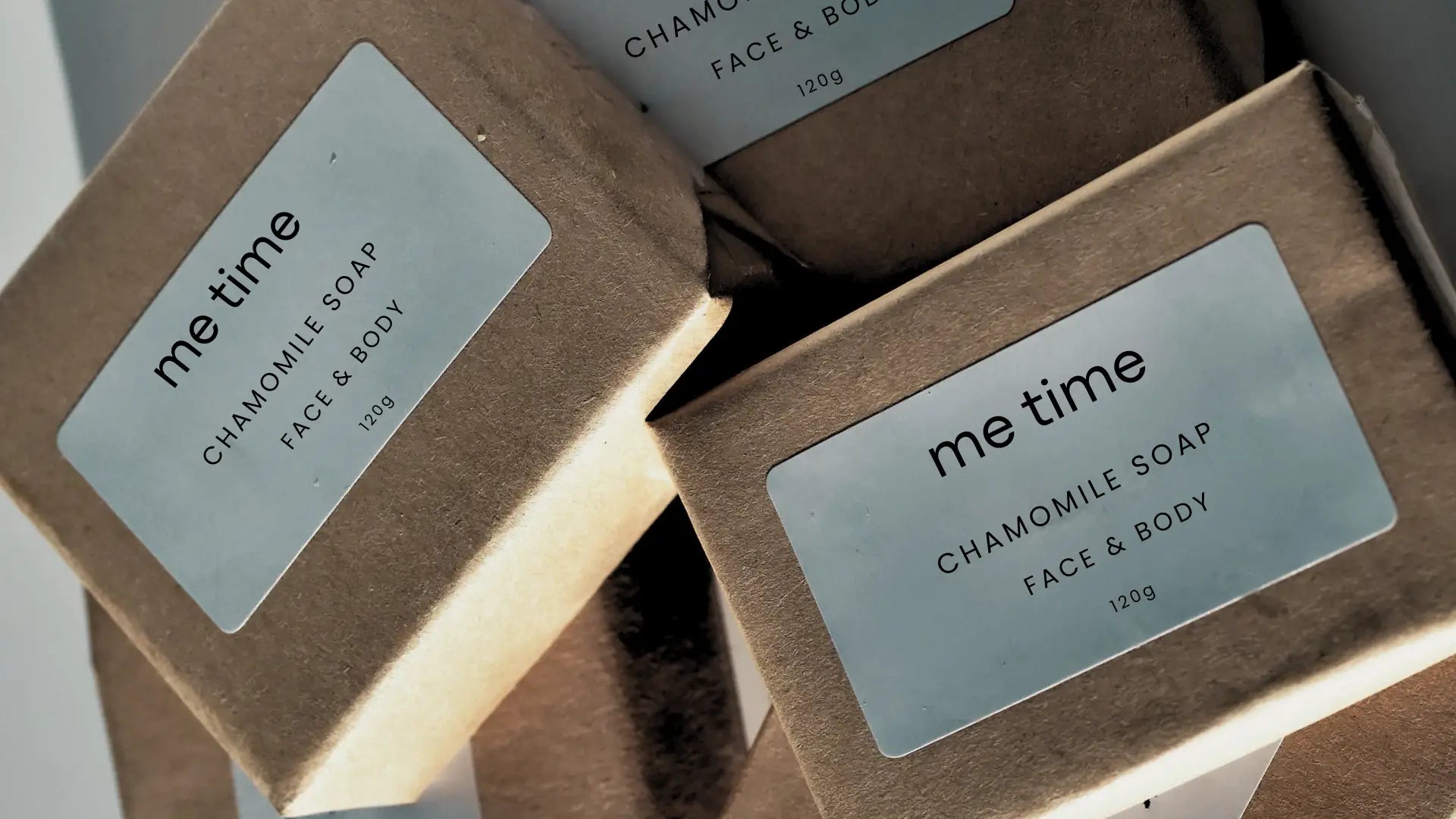 Three bars of 'me time' chamomile soap in brown kraft sustainable packaging on a light gray background. made in UAE