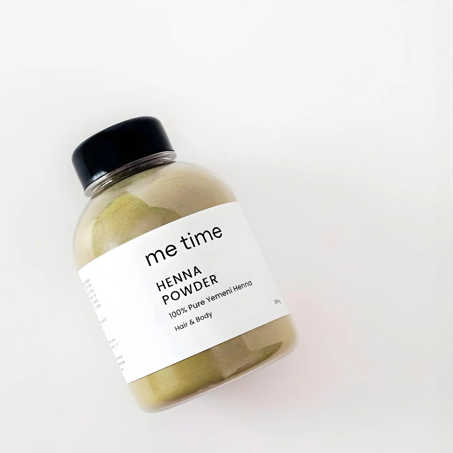 Jar of yemeni henna powder with a black lid on a white background