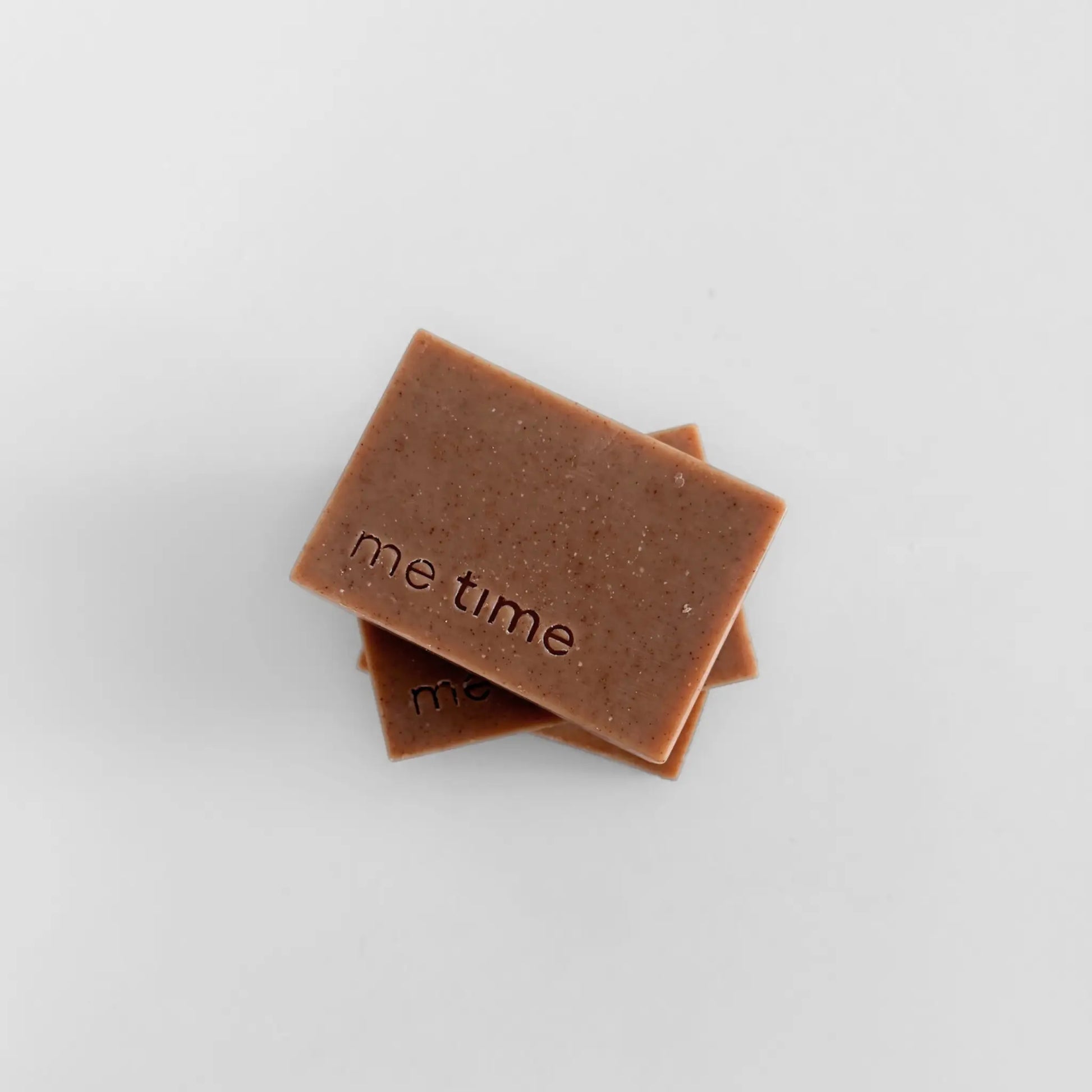 Two brown soap bars with 'me time' branding on a light gray background