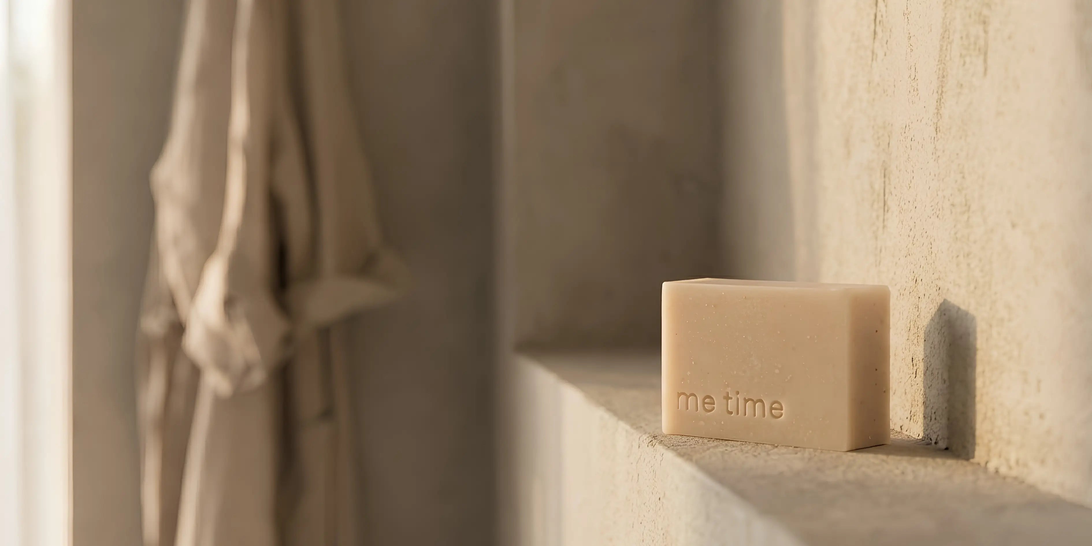 Bar of soap with 'the time' branding on a stone shelf.