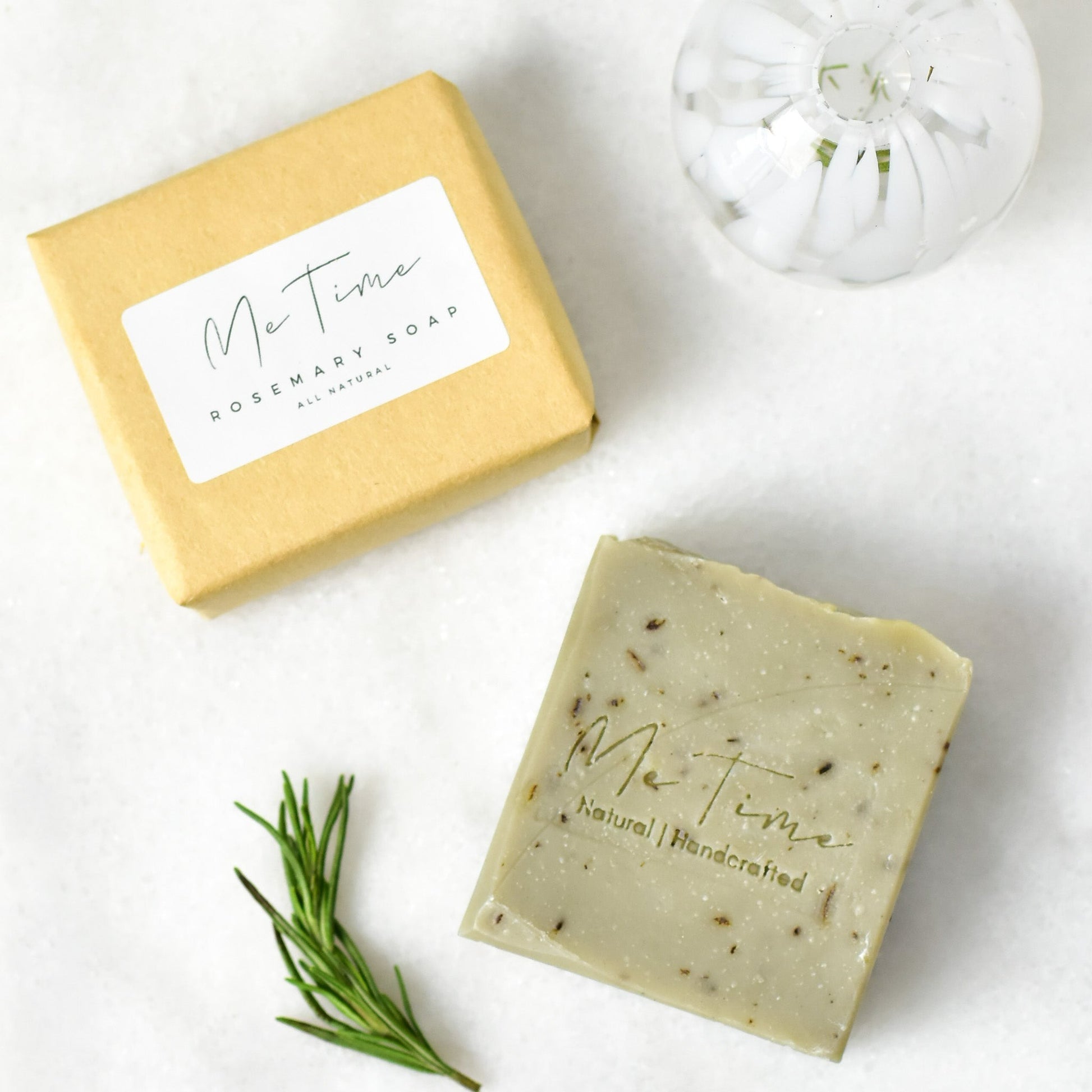 Handmade natural artisan soap bar with rosemary and clay, featuring gentle exfoliation and deep hydration properties. The soap is crafted with olive oil, coconut oil, sunflower oil, and shea butter, and is scented with rosemary essential oil. It includes white, green, and grey clay for purifying and rejuvenating the skin.